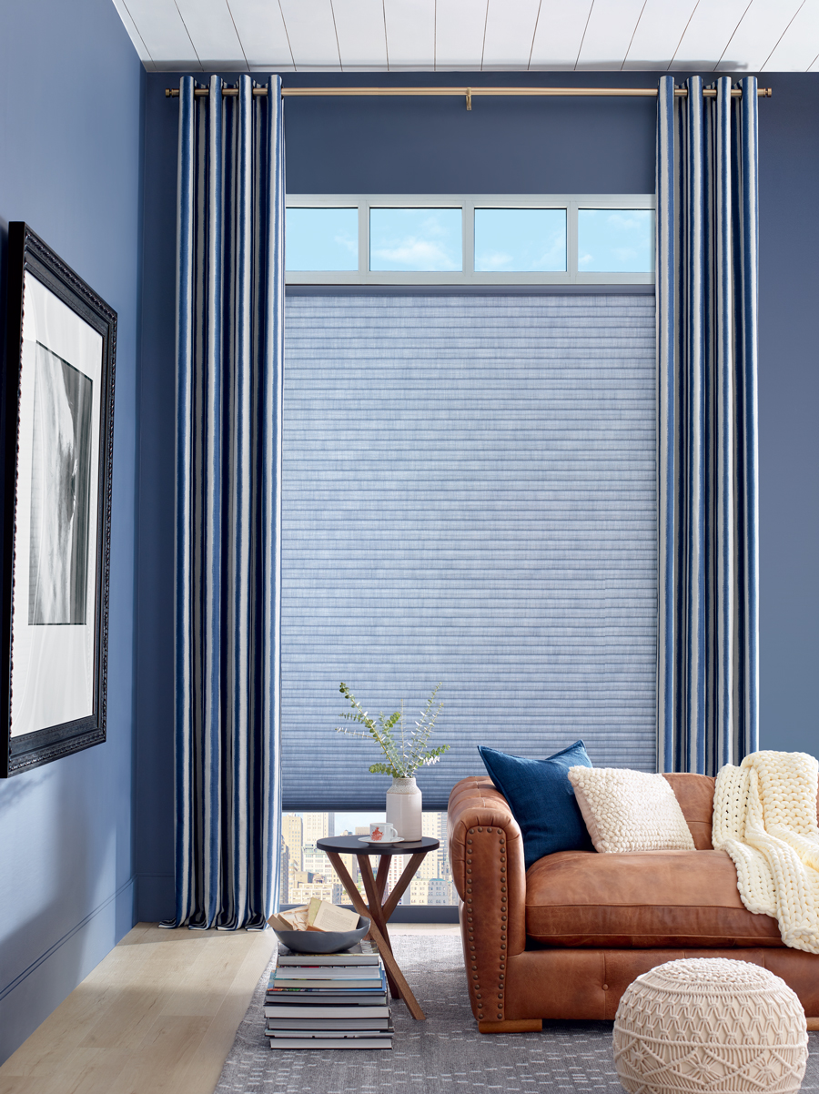 blue living room in Minneapolis MN with tall drapery on a gold rod with blue honeycomb shades